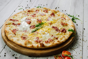 Pizza Carbonare with mozzarella, becon, egg and onion on the white background