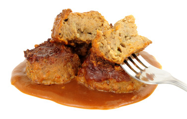 Pork faggots and gravy isolated on a white background