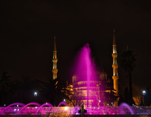 Eine bunte Fontäne von Springbrunnen bei Nacht