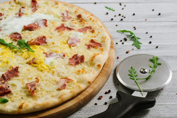 Pizza Carbonare with mozzarella, becon, egg and onion on the white background