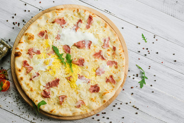 Pizza Carbonare with mozzarella, becon, egg and onion on the white background