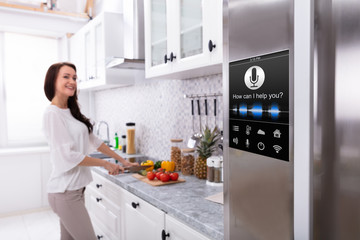 An Oven With Voice Recognition Function Near Woman Cutting Vegetables