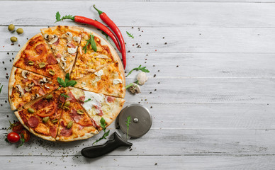 A slices on different kinds of pizza set in one rounded piece on wooden background