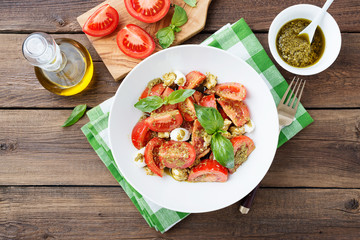 Tomato salad with basil,mozzarella cheese and pesto sauce .