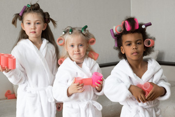 Three girls friends with pink hair curlers.