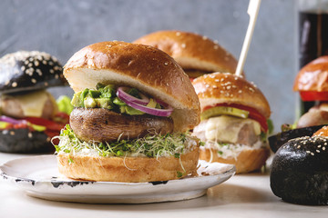 Variety of homemade classic, vegan and mini burgers in wheat and black buns with beef and veal...