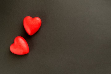 Obraz premium Valentine card with heart decor on a black table. Top view with space for your greeting.