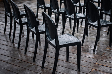Black chairs in the rain on the street