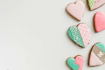Painted pink and colored, ginger and honey cakes and cookies. In the shape of a heart. On a light wooden background. Frame. Place for text. The concept of love, mother's day, cooking, St. Valentine.