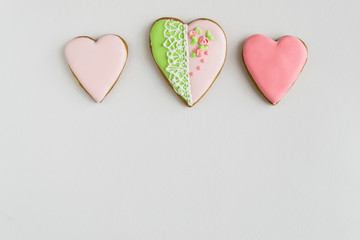 Frame. Place for text. The concept of love, mother's day, cooking, St. Valentine. Painted pink and colored, ginger and honey cakes and cookies. In the shape of a heart. On a light wooden background.
