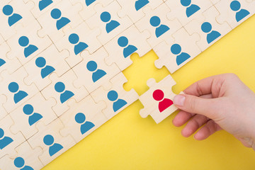 Teamwork concept. hand completes the missing piece of the puzzle.