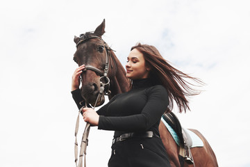 A happy girl communicates with her favorite horse. The girl loves animals andhorseback riding