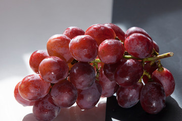 bunch of grapes with drops of water on a black and white background