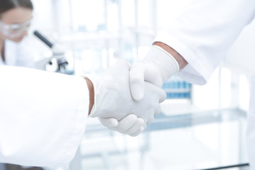 Doctors in lab coats greeting each other with handshake