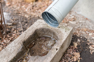 Flowing water from the gutter close up shot, shallow depth of field.