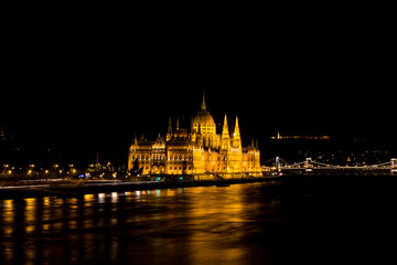 Fototapeta na wymiar Budapest Parliament in Hungary at night on the Danube river with bridge view.