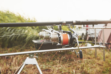 Carp fishing rods standing on special tripods. Expensive coils and a radio system of crochet
