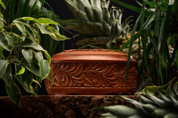 Wooden chest on the background of tropical plants and pineapple. A treasure box.