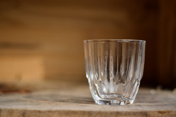 Empty glass on the dark wooden table.