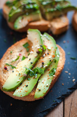 Close-up of fresh avocado toast with spices on dark background 