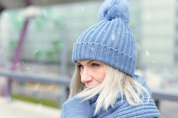Attractive blond woman snuggling into a warm scarf