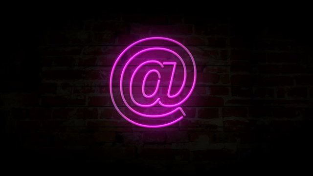 E-mail at @ neon symbol on brick wall. Internet communication sign light on brick wall background. Retro style glowing icon.