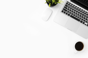White office desk table with laptop computer, cup of coffee and supplies. Top view with copy space, flat lay.