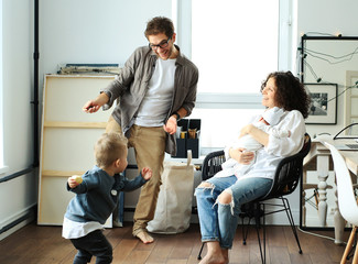 Happy young family laughing and dancing at home