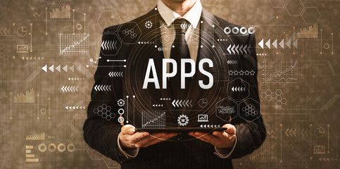 Apps with businessman holding a tablet computer on a dark vintage background