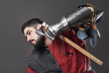 Medieval knight on grey background. Portrait of brutal dirty face warrior with chain mail armour...