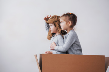 Playful childhood. Little boy having fun with cardboard box. Boy pretending to be pilot. Little boy...