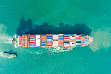 Aerial view and top view. Container ship in pier with crane bridge carries out export  and import business in the open sea. Logistics and transportation