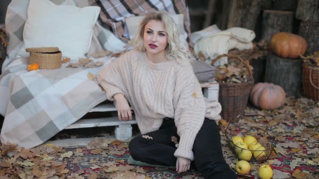 Blonde girl in a beige sweater on a photo shoot
