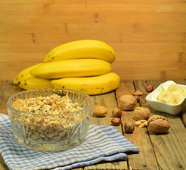 background with muesli, a bunch of bananas and nuts