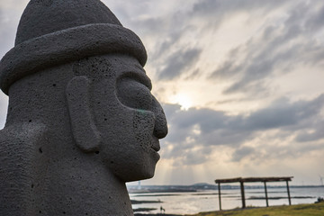 Close-up of harubang sculture at a park near the ocean of Jeju Island, South Korea.
