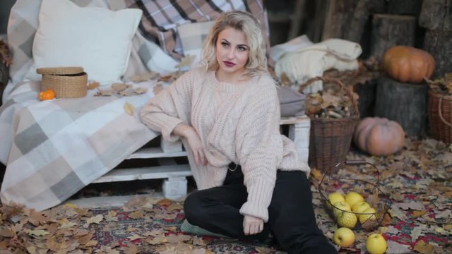 Blonde girl in a beige sweater on a photo shoot