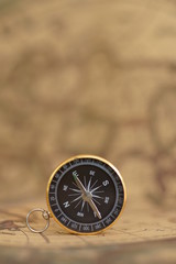 Fototapeta na wymiar Compass on blur vintage map background, retro color tone, direction journey planning concept
