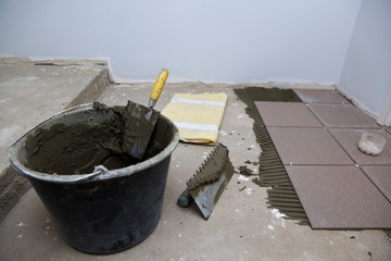 A plastic construction bucket with cement based glue ready to be used for gluing ceramic tiles.