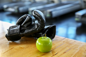 Healthy lifestyle sport. Boxing glove, and healthy food on wooden.  green apple in the gym or sport club. Healthy lifestyle sport equipment fitness
