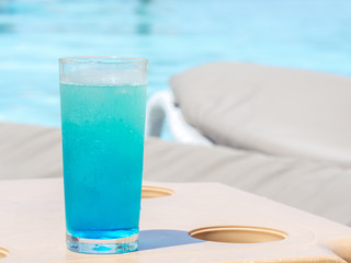 glass with a bright blue drink on the table on the hotel terrace.