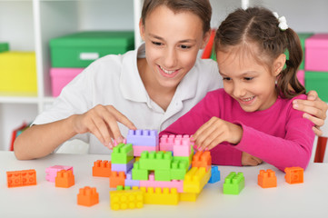 Portrait of brother and sister playing with colorful plastic blocks together
