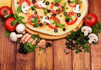 Pizza with shrimps. Top view. Wooden board background