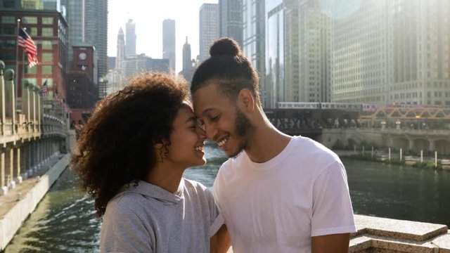 Cute African American couple take a break along the Chicago River after their morning workout.