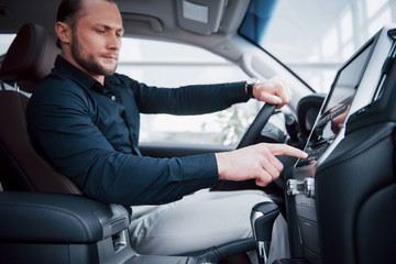 Close up view of a young man driving a car. Start a business trip. Test drive a new auto