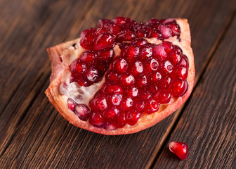 Pomegranate fruit close-up. Ripe pomegranate fruit on wooden vintage background.