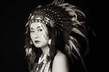 Duotone portrait of young beautiful asian woman in vintage costume of American Indian