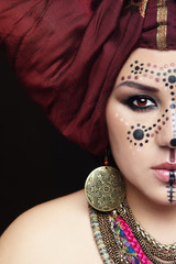 Portrait of young beautiful asian woman with ethnic face paint and turban