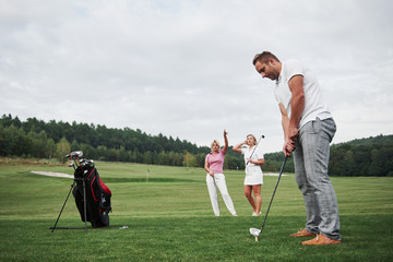 Obraz premium Group of stylish friends on the golf course learn to play a new game
