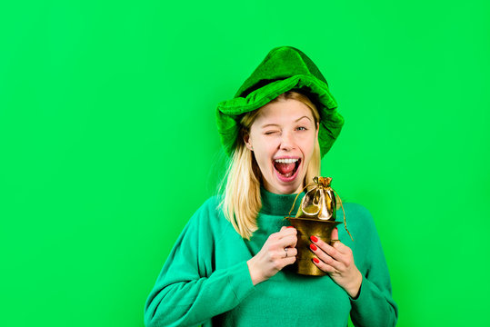 Green top hat. Blonde girl in Leprechaun costume holds bag with gold. Leprechaun. Bag with gold. Green leprechaun. Green hat with clover. Saint Patrick's Day - Celebrations Traditions. Saint Patrick.