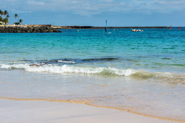 Fototapeta na wymiar View of Playa de las Cucharas beach in Costa Teguise, Lanzarote, Spain, clear turquoise waters, selective focus